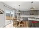 Dining area with a wooden table set with bench seating, gray cabinets, and pendant lighting at 10865 Mystic View Ct, Indianapolis, IN 46239