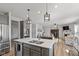Open concept kitchen with center island and breakfast bar seating and access to living area at 10865 Mystic View Ct, Indianapolis, IN 46239