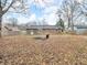 Spacious backyard with a leafless ground cover, a brick house, and a metal burn barrel at 12386 S Hillview Dr, Columbus, IN 47201