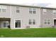 Exterior view of the home's backyard with green lawn, patio, and neutral siding at 1257 Newton St, Avon, IN 46123