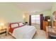 Bedroom with a cozy bed, wooden dresser, and a window with dark purple curtains at 1280 Vicksburg S Dr, Greenwood, IN 46143