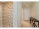 Hallway with patterned wallpaper, neutral tile flooring, and a dark-colored desk at 1280 Vicksburg S Dr, Greenwood, IN 46143