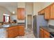 Open kitchen featuring light wood cabinets, stainless steel refrigerator, and neutral countertops at 1280 Vicksburg S Dr, Greenwood, IN 46143
