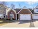 Charming single-story brick home featuring a two-car garage, a well-manicured lawn, and lovely landscaping at 1307 Estuary Dr, Indianapolis, IN 46217