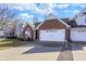 Inviting single-story brick home featuring a two-car garage, a well-manicured lawn, and pretty landscaping at 1307 Estuary Dr, Indianapolis, IN 46217