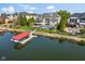 An aerial view showcases a brick home with a pool, covered boat dock, and scenic waterfront at 13499 Marjac Way, Fishers, IN 46055