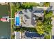 Aerial view showcasing a home with a pool, patio, landscaped yard, and boat dock on the water at 13499 Marjac Way, Fishers, IN 46055