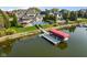 An aerial view of a beautiful brick home with a pool, dock, and boat lift on the water at 13499 Marjac Way, Fishers, IN 46055