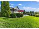 Landscaped backyard featuring a pool, patio with red umbrella, and lush green lawn, perfect for outdoor relaxation at 13499 Marjac Way, Fishers, IN 46055