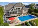 Aerial view of the backyard pool and patio featuring an umbrella table and chairs near the beautiful brick home at 13499 Marjac Way, Fishers, IN 46055