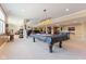 Large carpeted basement featuring pool table, bar area, and comfortable seating area at 13499 Marjac Way, Fishers, IN 46055
