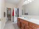 Bright bathroom with tile floors, a large mirror over a wooden vanity, and a separate shower room at 13499 Marjac Way, Fishers, IN 46055