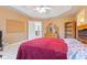 Bedroom with a red quilt, a wooden dresser with mirror and an open doorway to the staircase at 13499 Marjac Way, Fishers, IN 46055