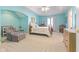 Bright primary bedroom with a tray ceiling, seating area, and neutral carpeting at 13499 Marjac Way, Fishers, IN 46055