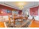 Formal dining room with rich wood accents, elegant chandelier, and large window enhances the dining experience at 13499 Marjac Way, Fishers, IN 46055