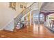 Grand foyer with hardwood floors, a staircase, and views into the living room exudes elegance at 13499 Marjac Way, Fishers, IN 46055