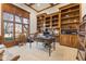 Detailed home office with coffered ceilings, custom shelving, large windows, and refined decor at 13499 Marjac Way, Fishers, IN 46055