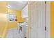 Well-lit laundry room with washer, dryer, built-in cabinets and bright yellow walls at 13499 Marjac Way, Fishers, IN 46055