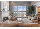 Bright living room featuring a cozy fireplace, large windows with lake views, and comfortable seating at 13499 Marjac Way, Fishers, IN 46055