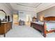 Large primary bedroom with soft gray walls and carpet, a bed, dressers, and water view windows at 13499 Marjac Way, Fishers, IN 46055