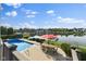Outdoor patio area with pool, table, and landscaping, perfect for entertaining with a lake view at 13499 Marjac Way, Fishers, IN 46055