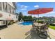 Relaxing poolside patio featuring a large patio umbrella and an outdoor dining set at 13499 Marjac Way, Fishers, IN 46055