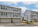 Exterior of townhouses with gray siding, multiple windows, white railings, and garages at 14041 Wimbleton Way, Fishers, IN 46037