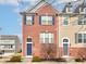 Brick townhome featuring blue shutters, a blue door, and manicured landscaping at 14041 Wimbleton Way, Fishers, IN 46037