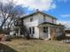 Two-story home with a classic front porch, complemented by an exterior metal staircase, and established yard at 159 E Washington St, Morgantown, IN 46160