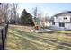 Large, fenced backyard featuring a playground and a view of the two-story home at 1634 Muessing Rd, Indianapolis, IN 46239