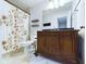 Traditional bathroom with a wooden vanity, decorative shower curtain, and tiled floors at 1634 Muessing Rd, Indianapolis, IN 46239