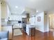 White kitchen with stainless steel appliances, a kitchen island and warm wood floors at 1634 Muessing Rd, Indianapolis, IN 46239