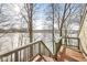 A wood deck looks out to a serene, frozen lake surrounded by bare trees in winter at 18 Point Ln, Arcadia, IN 46030