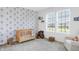 Charming Bedroom with balloon wallpaper, a crib, a plush rocking chair, and natural light at 1935 Ponsonby Dr, Westfield, IN 46074