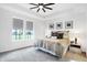 Inviting main bedroom featuring a plush carpet, tray ceiling, and a view of the outdoors through a large window at 1935 Ponsonby Dr, Westfield, IN 46074