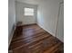 Bedroom with hardwood floors, fresh white paint, and natural light from the window at 2006 Medford Ave, Indianapolis, IN 46222