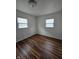 Bright bedroom featuring hardwood floors, fresh white paint, and natural light from two windows at 2006 Medford Ave, Indianapolis, IN 46222