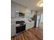 Renovated kitchen featuring grey cabinets, granite countertops, and stainless steel appliances at 2006 Medford Ave, Indianapolis, IN 46222