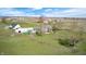 Aerial shot highlighting a house with outbuildings, extensive lawn, and parking for vehicles at 2141 E County Road 200 N, Danville, IN 46122