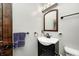 Compact bathroom features a black vanity, rounded mirror, and bronze fixtures at 2141 E County Road 200 N, Danville, IN 46122
