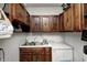 Practical laundry room with wooden cabinets, utility sink, and ample storage space at 2141 E County Road 200 N, Danville, IN 46122
