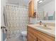 Inviting bathroom with wooden vanity, decorative shower curtain, and ample lighting at 2253 W Coil St, Indianapolis, IN 46260