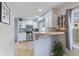 Bright, galley-style kitchen featuring white cabinets, stainless steel appliances, and a butcher block breakfast bar at 2253 W Coil St, Indianapolis, IN 46260