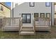 Backyard wooden deck with stairs leading to a grass yard and an entryway with double glass doors at 2406 Carrollton Ave, Indianapolis, IN 46205
