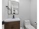Modern bathroom features a sleek vanity, a square mirror, and a convenient toilet at 2406 Carrollton Ave, Indianapolis, IN 46205