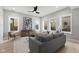 Living room featuring a large art piece and gray sofa illuminated by natural light from several windows at 2406 Carrollton Ave, Indianapolis, IN 46205