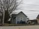 Exterior view of a two-story home with weathered siding and an overgrown front yard at 250 S Marion St, Morgantown, IN 46160