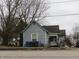 Exterior view of a two-story home with weathered siding and an overgrown front yard at 250 S Marion St, Morgantown, IN 46160