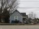 Exterior view of a two-story home with weathered siding and an overgrown front yard at 250 S Marion St, Morgantown, IN 46160