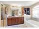 Bright bathroom features double sinks, stylish vanity, soaking tub, and tiled glass shower at 2504 Boylston Ct, Zionsville, IN 46077